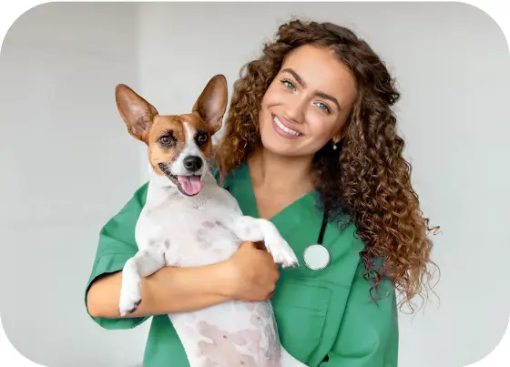 Uma veterinária sorridente segura um cachorro pequeno, ambos com expressões felizes, em um ambiente claro e acolhedor.